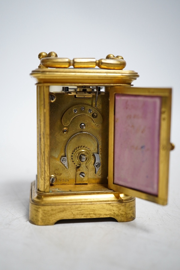 A miniature brass and enamel figurative panelled carriage timepiece, 7cm high. Condition - both gilt and enamel panels marked